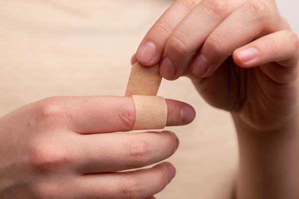free hand wrapping band-aid around finger